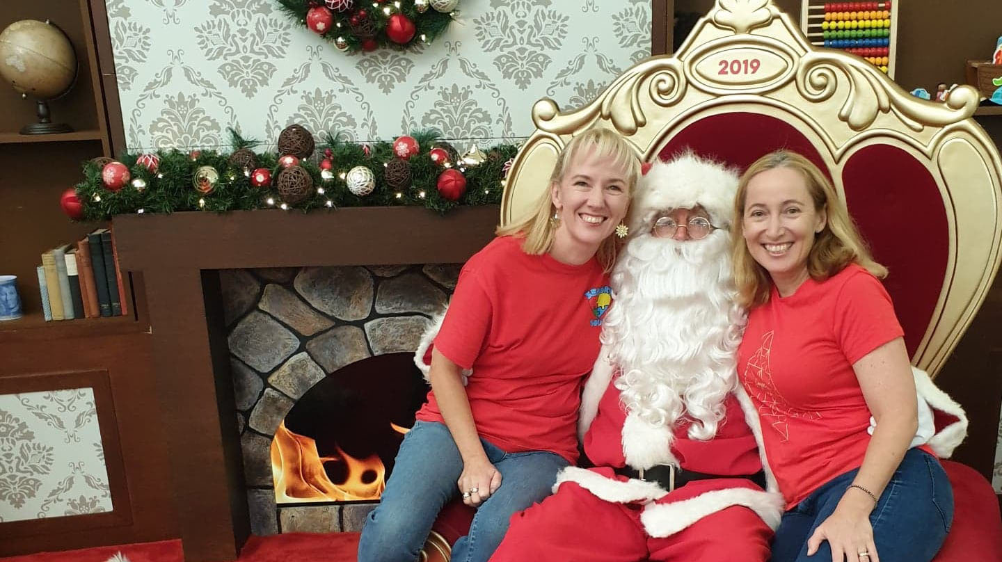 Two women in red t-shirts with Santa 