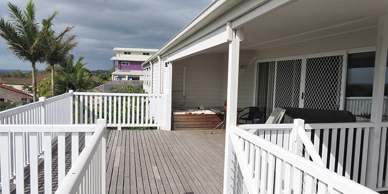 Large wooden deck surrounded by low white wooden railings