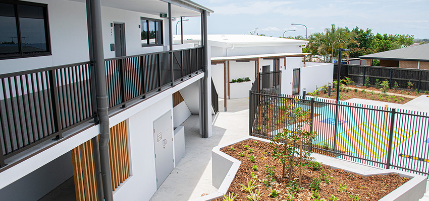 Photo of rear of apartment building with disabled parking in the foreground