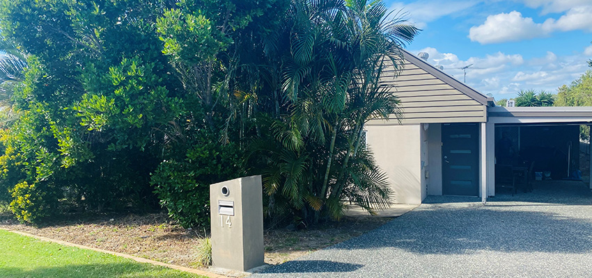 Front of house with grey facade and a mailbox reading 14