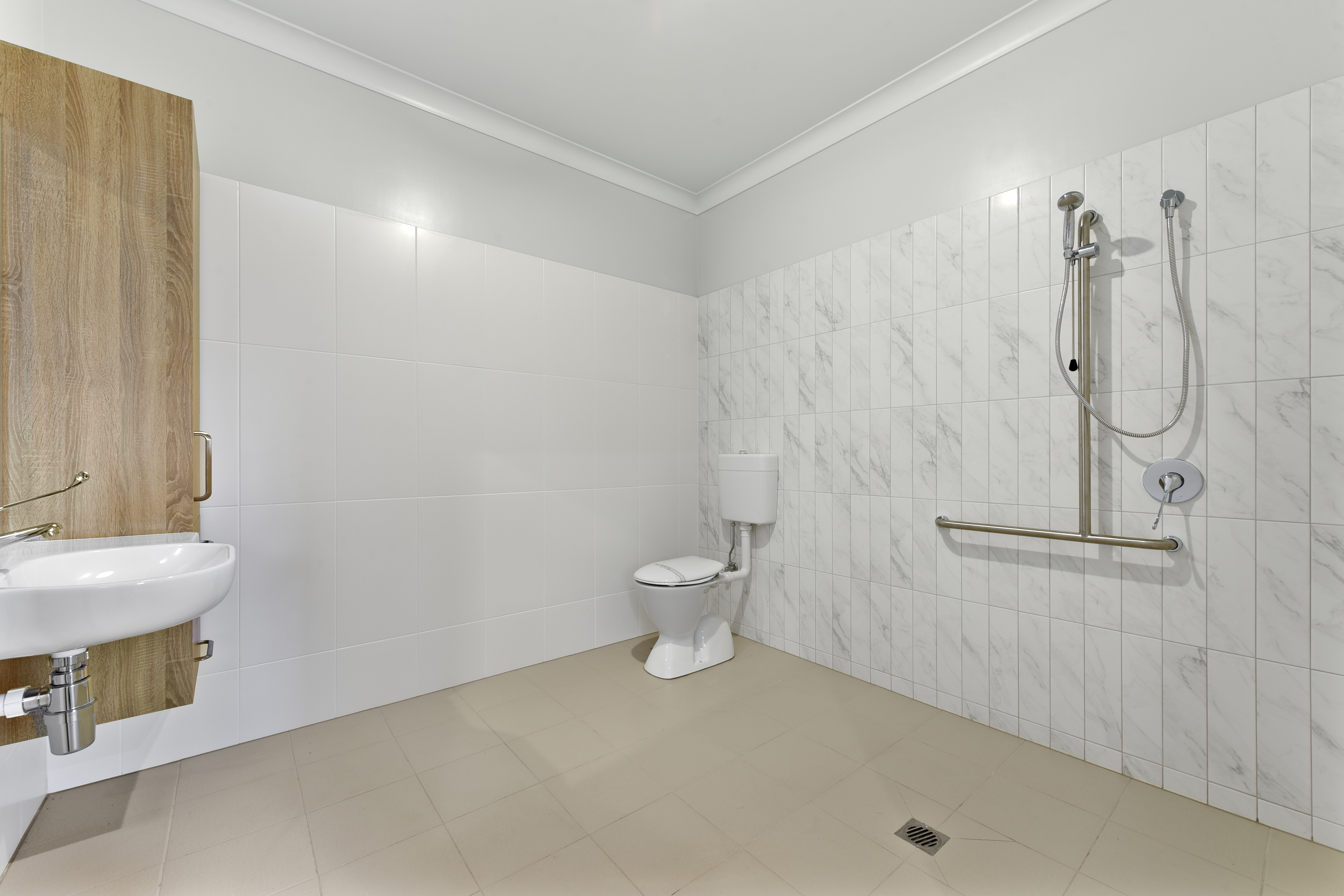 Modern accessible bathroom with light grey and white tiles