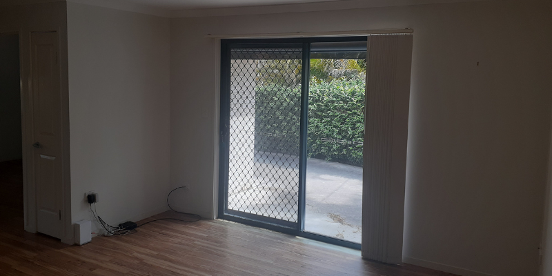 Living room of unit. Polished wood flooring, fly screen and outdoor area. 