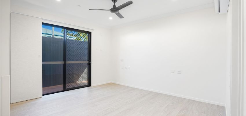 Empty room with white walls and black sliding doors