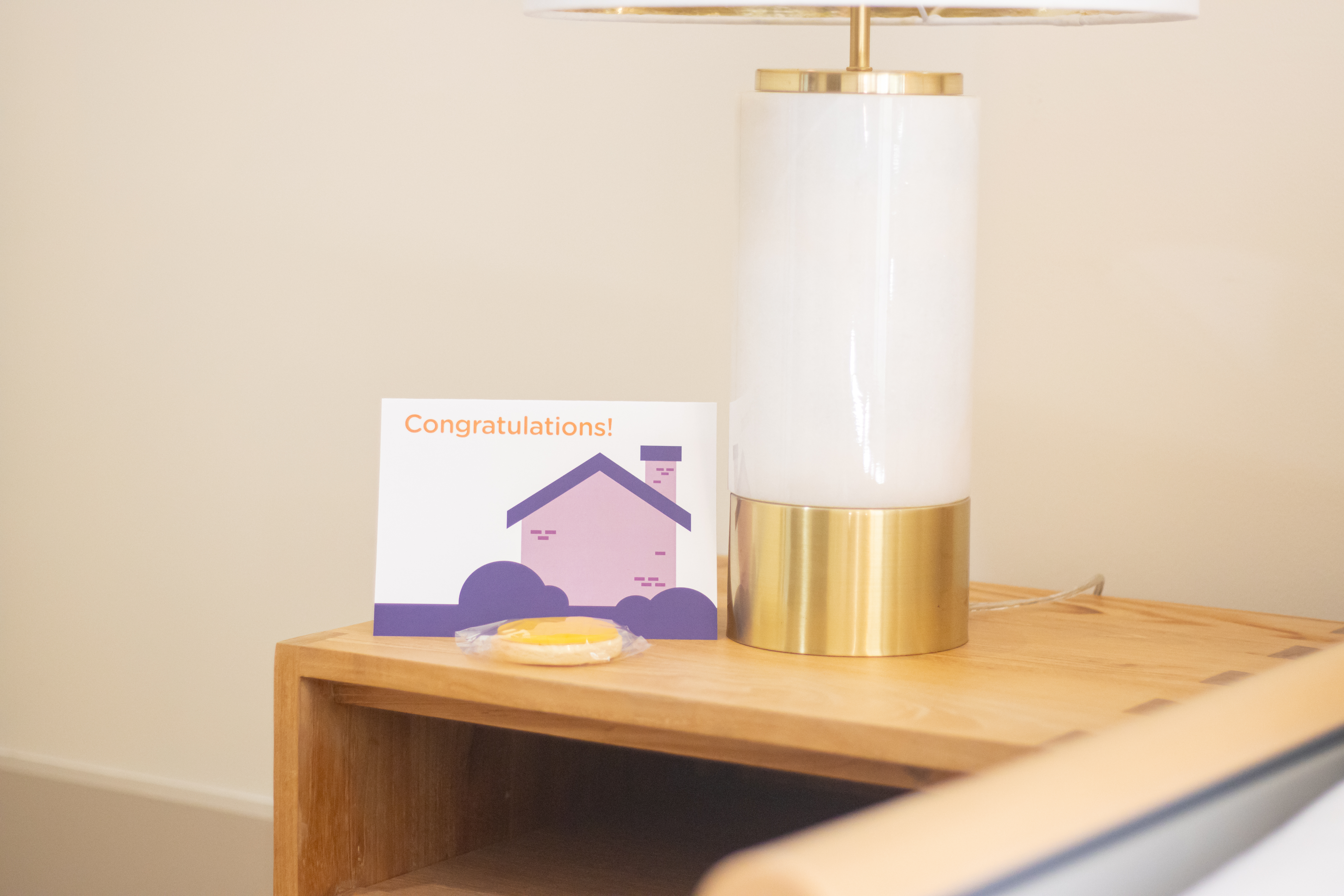 A bedside table with a congratulations card on it