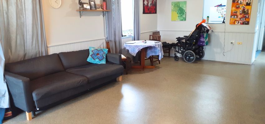 Photo of a lounge room looking towards a kitchen