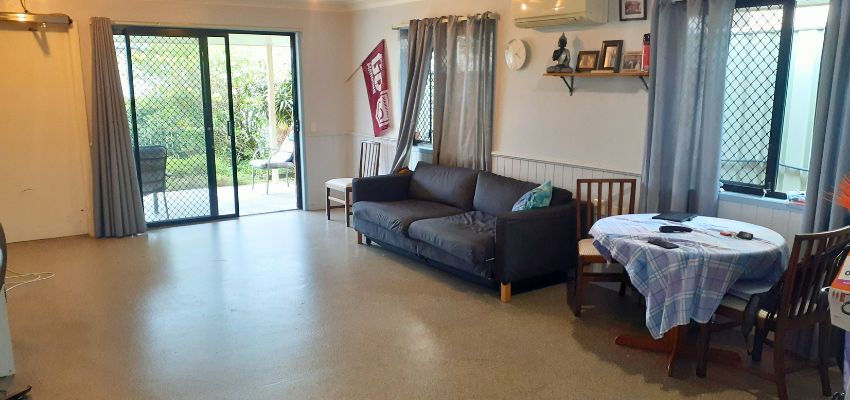 Photo of a lounge room with a double couch and large sliding door