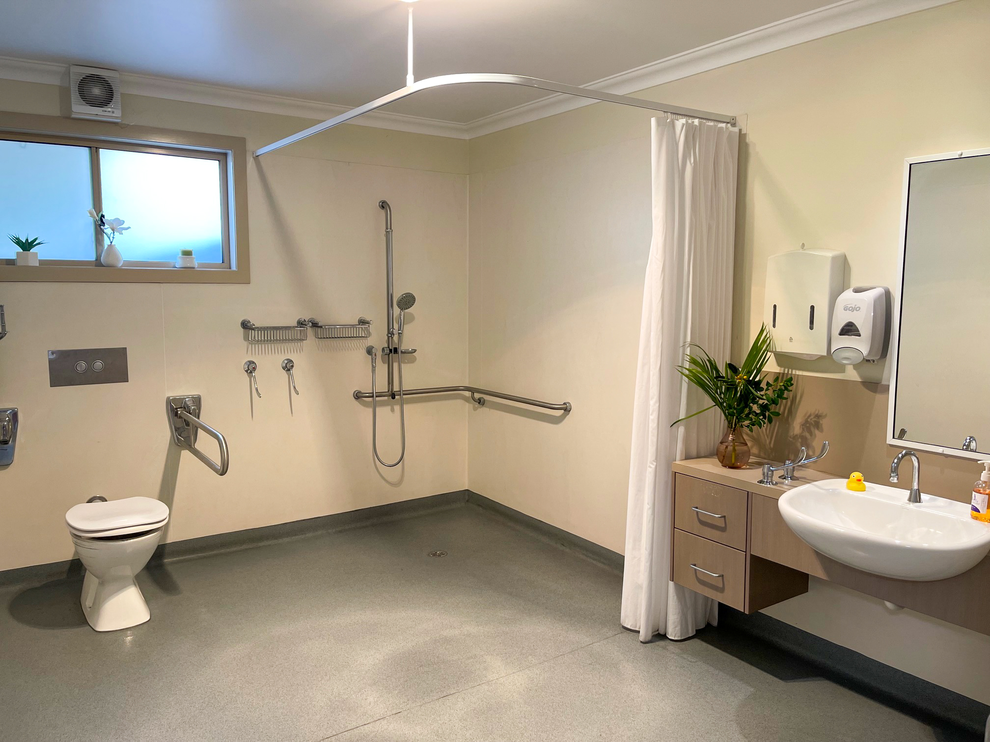 A wet room bathroom with cream walls