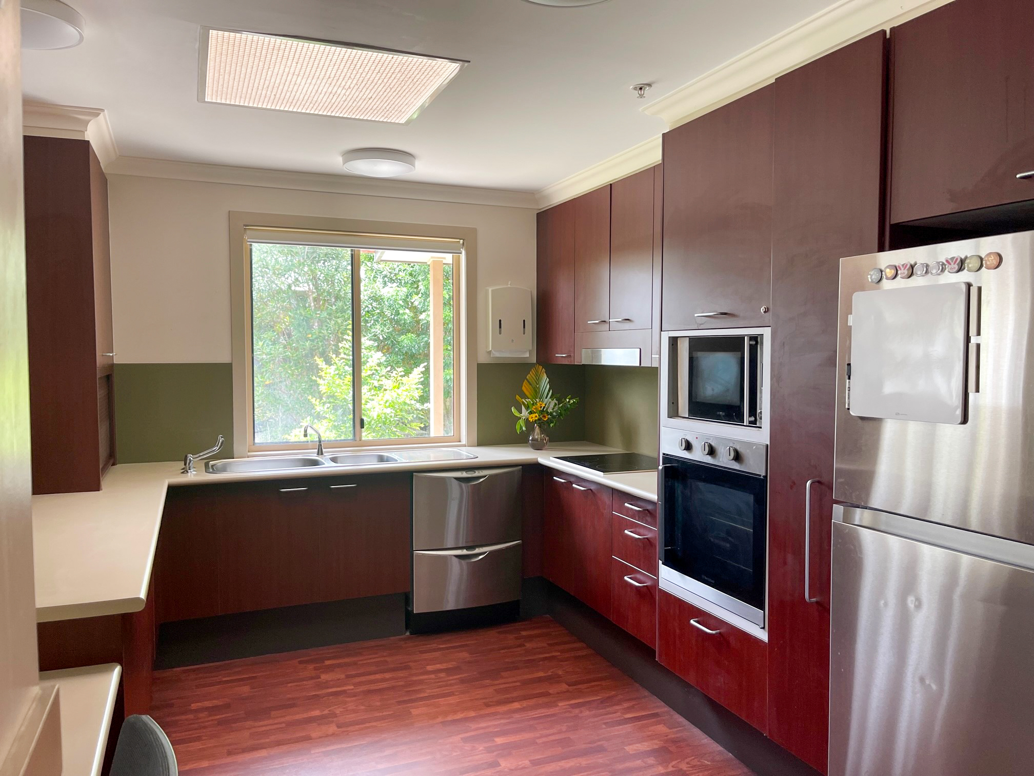 A kitchen with dark brown cabinets