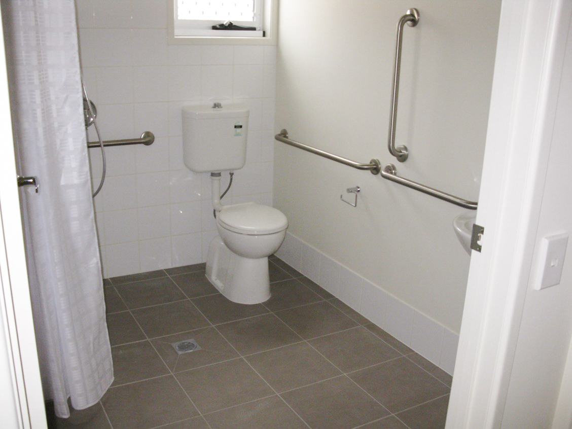 A bathroom with accessible rails along the walls