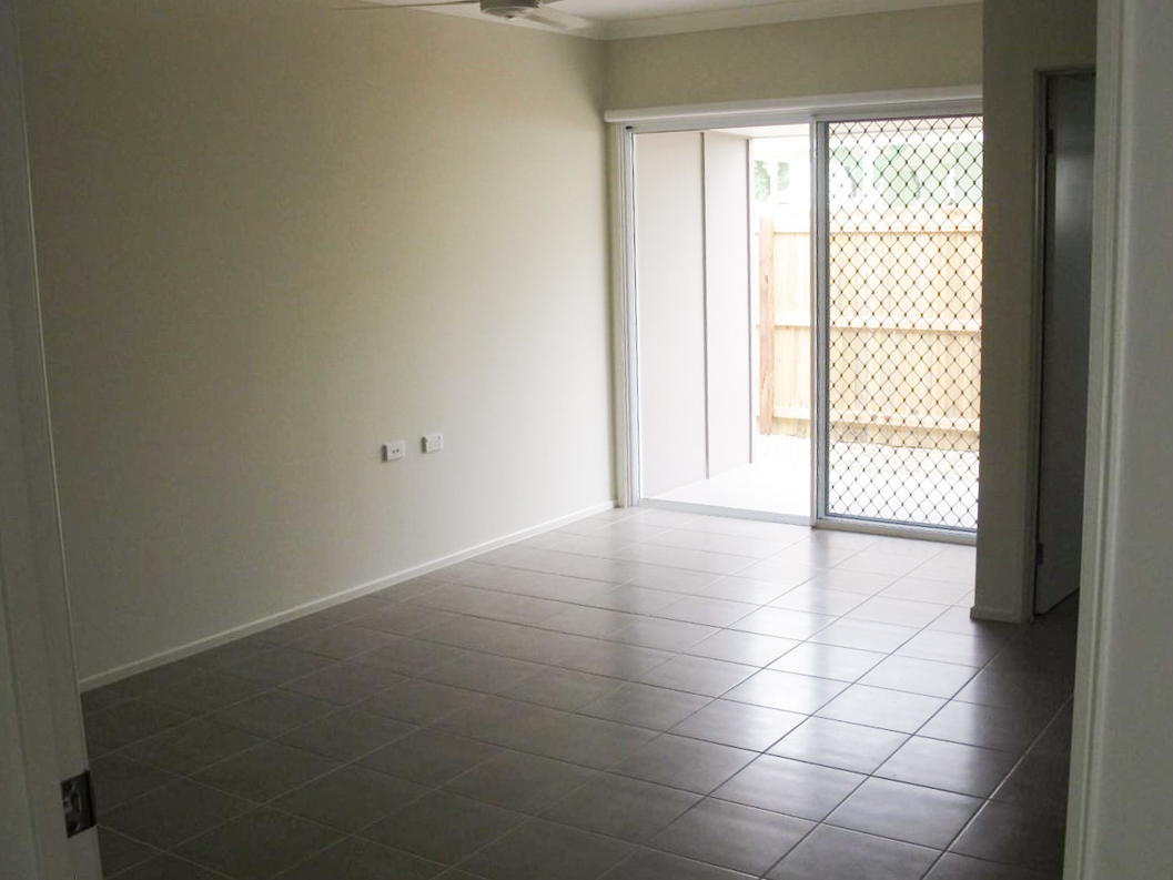 A bedroom with a floor to ceiling window on the far side