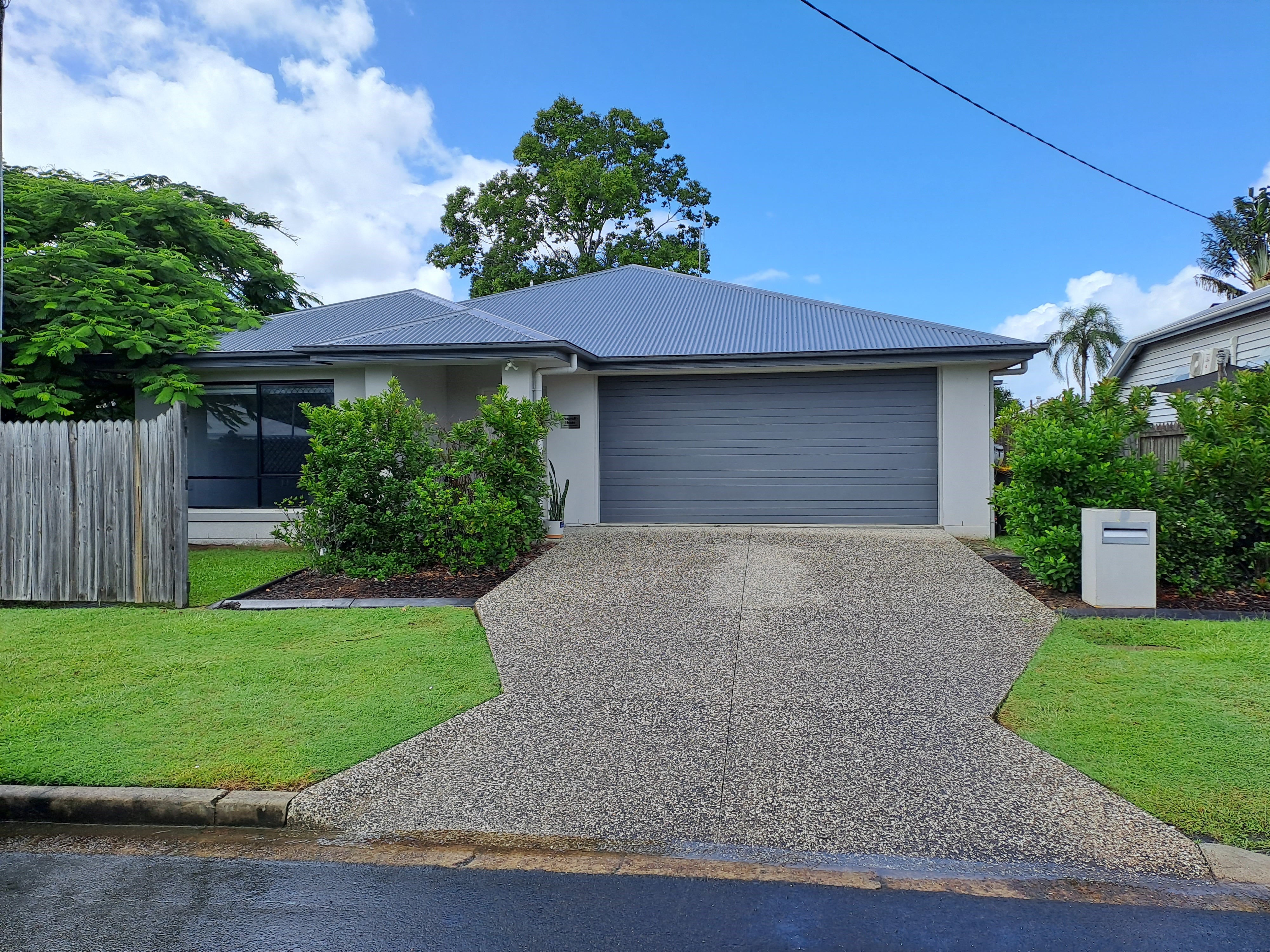 Front of a grey home with a front lawn