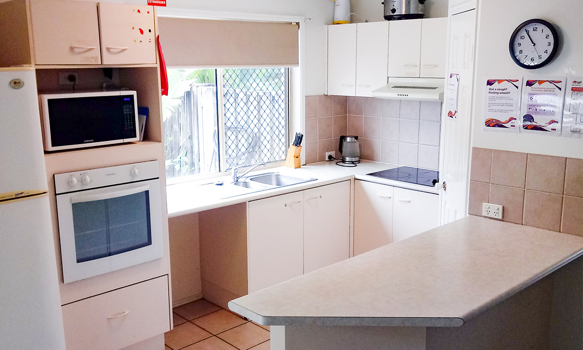 A kitchen with a tile floor and wooden cabinets