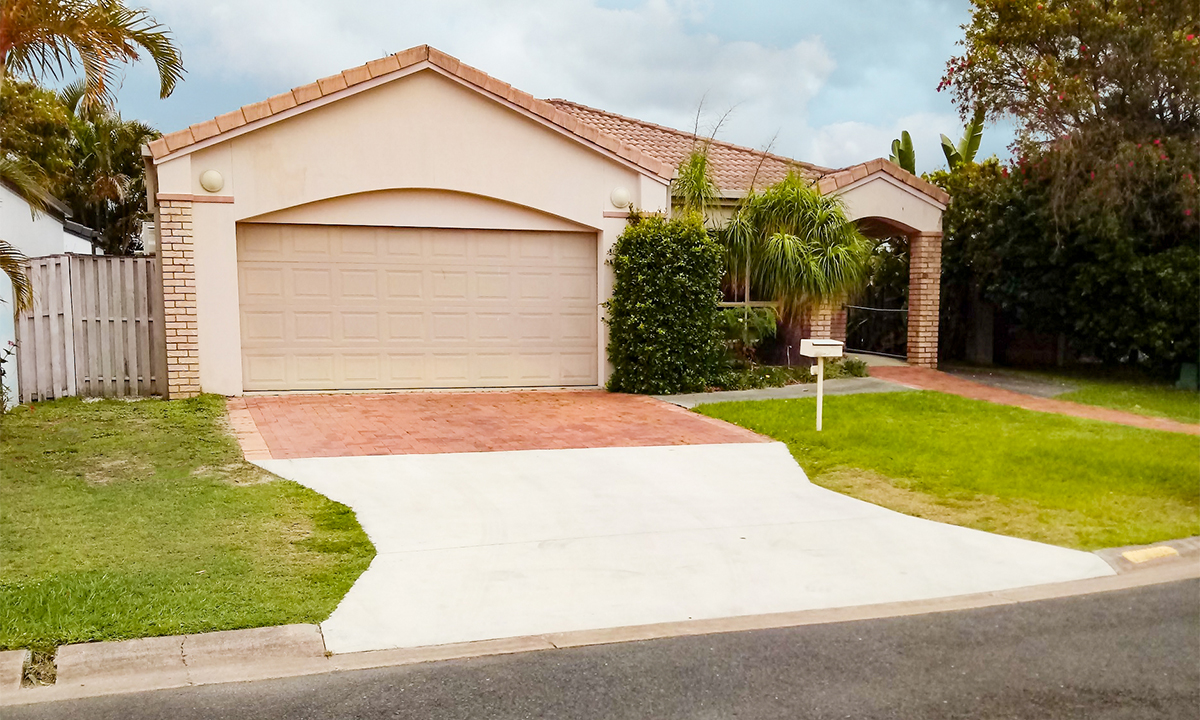 Front of a light brown brick home with a large garage