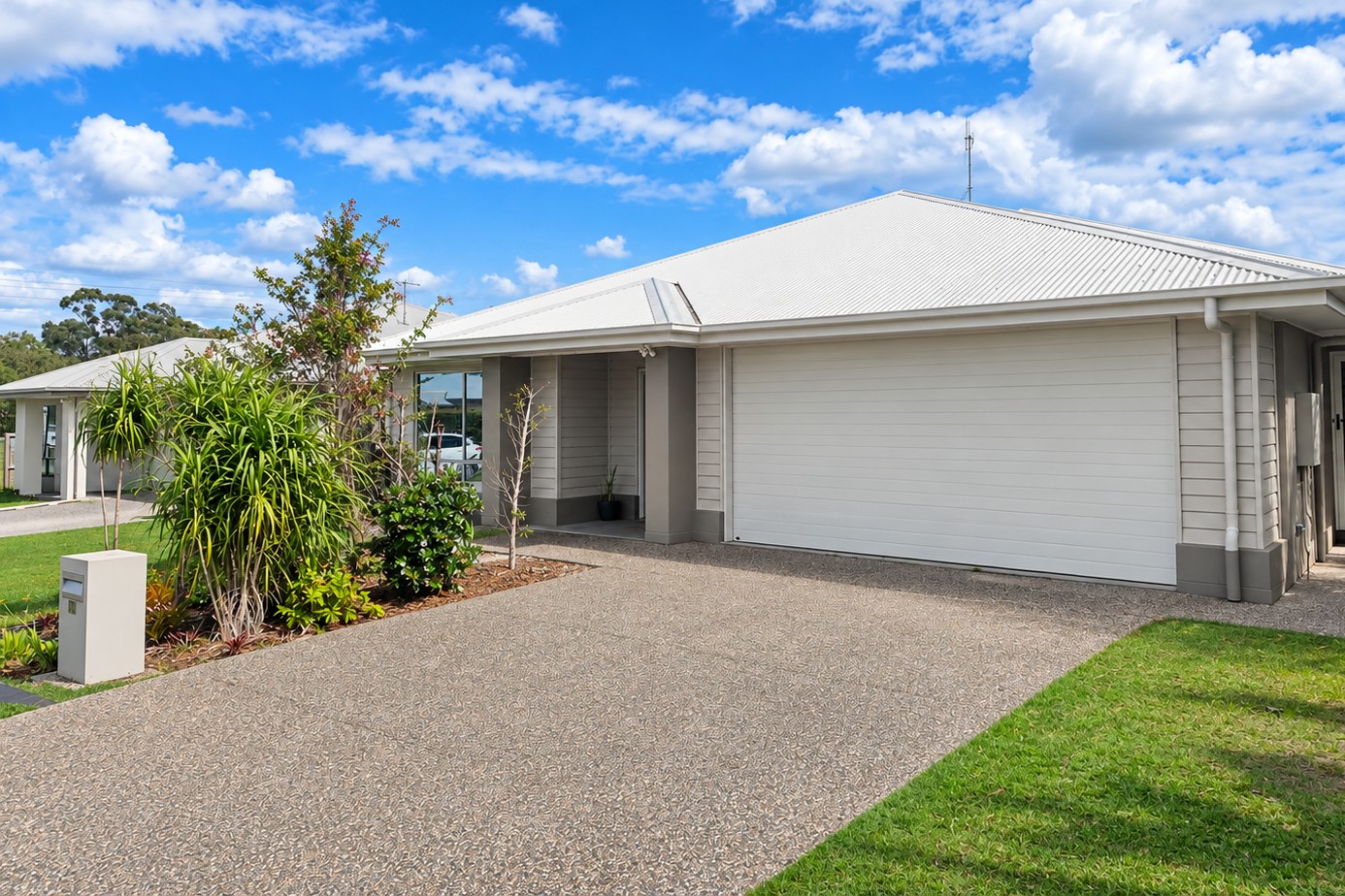 An image showing the front of the property. There is a driveway and facade visible