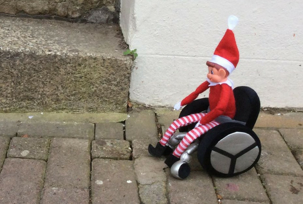 Elf on the shelf - accessibility Elf on the shelf toy in a wheelchair, outdoors, paved ground