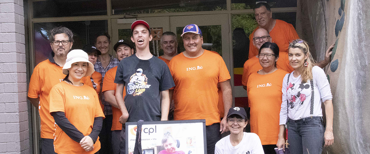 Group photo of ING volunteers, CPL staff and CPL client smiling