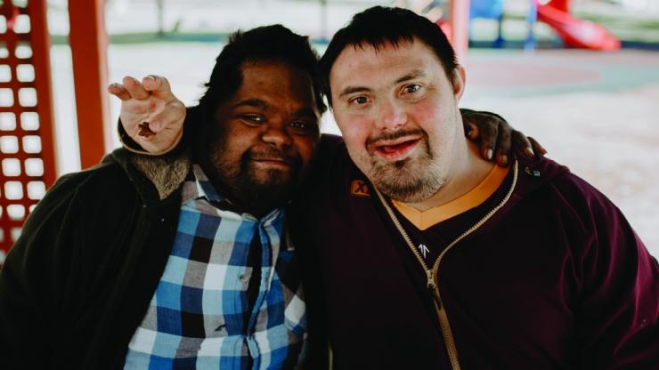 Two people sat together smiling at the camera