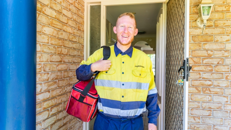 Scott in hi visibility clothing standing in the front doorway of his house