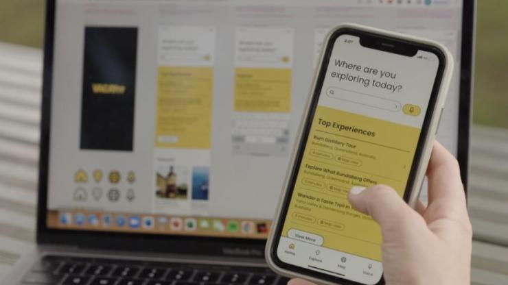 A phone showing the Vacayit app, with a computer behind it showing the Vacayit website