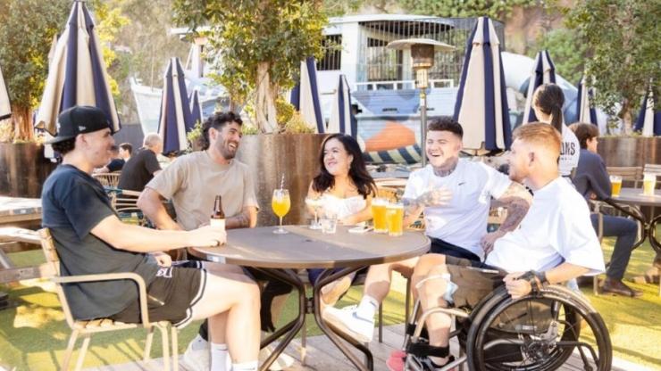 A group of people sitting around a table talking and laughing
