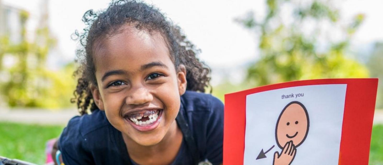 girl with a disability smiles at the camera