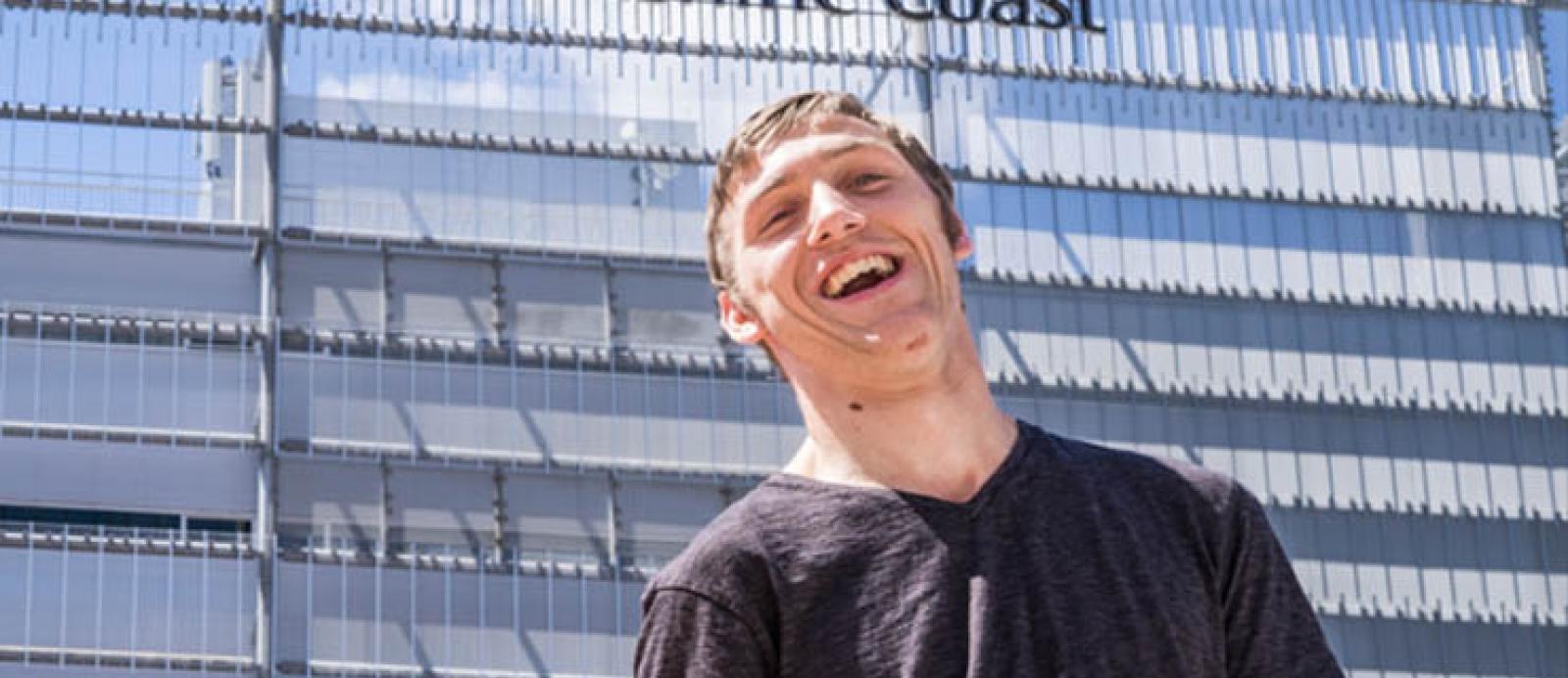 Young man with a disability smiles while being outside 