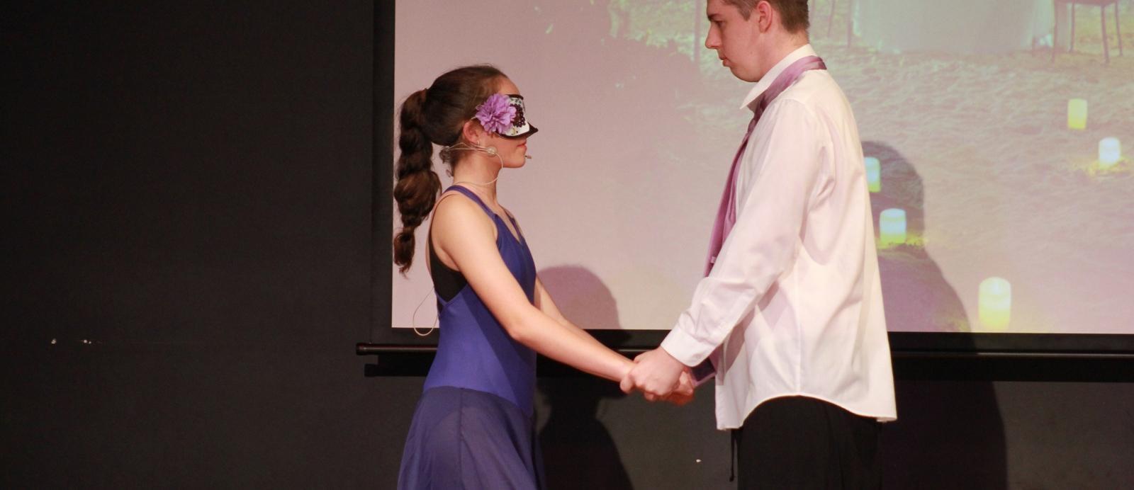 young woman and man look at each during screech arts performance